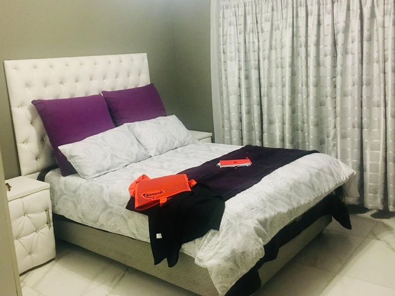 A well-maintained bedroom featuring tiled flooring and neutral wall finishes, providing a comfortable and functional living space.