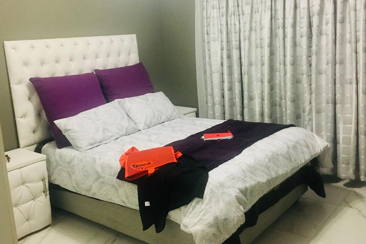 A well-maintained bedroom featuring tiled flooring and neutral wall finishes, providing a comfortable and functional living space.