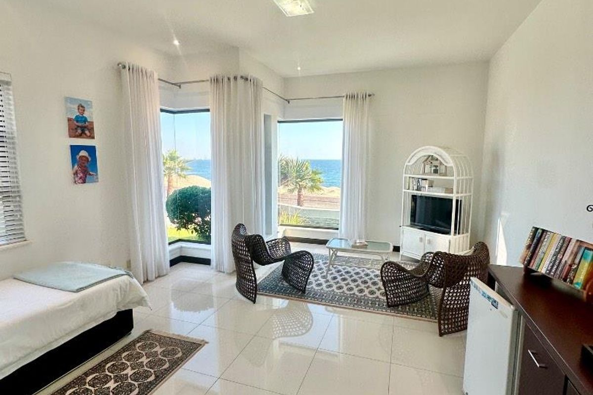 Bright living area featuring large windows with ocean views, neutral tiled flooring, and a clean, open layout.