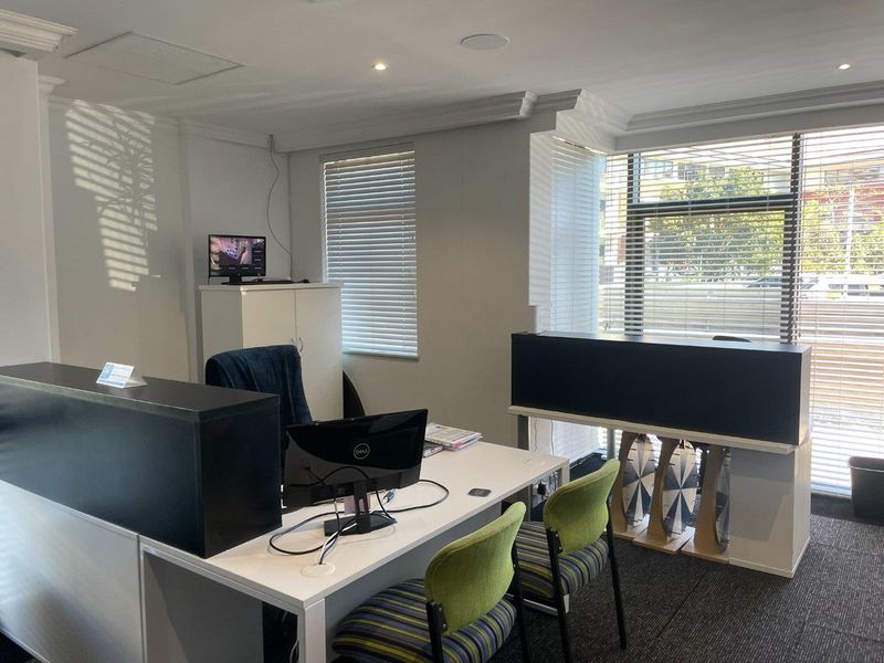A functional office space featuring recessed lighting, crown molding, and venetian blinds, providing a professional environment with carpeted flooring.