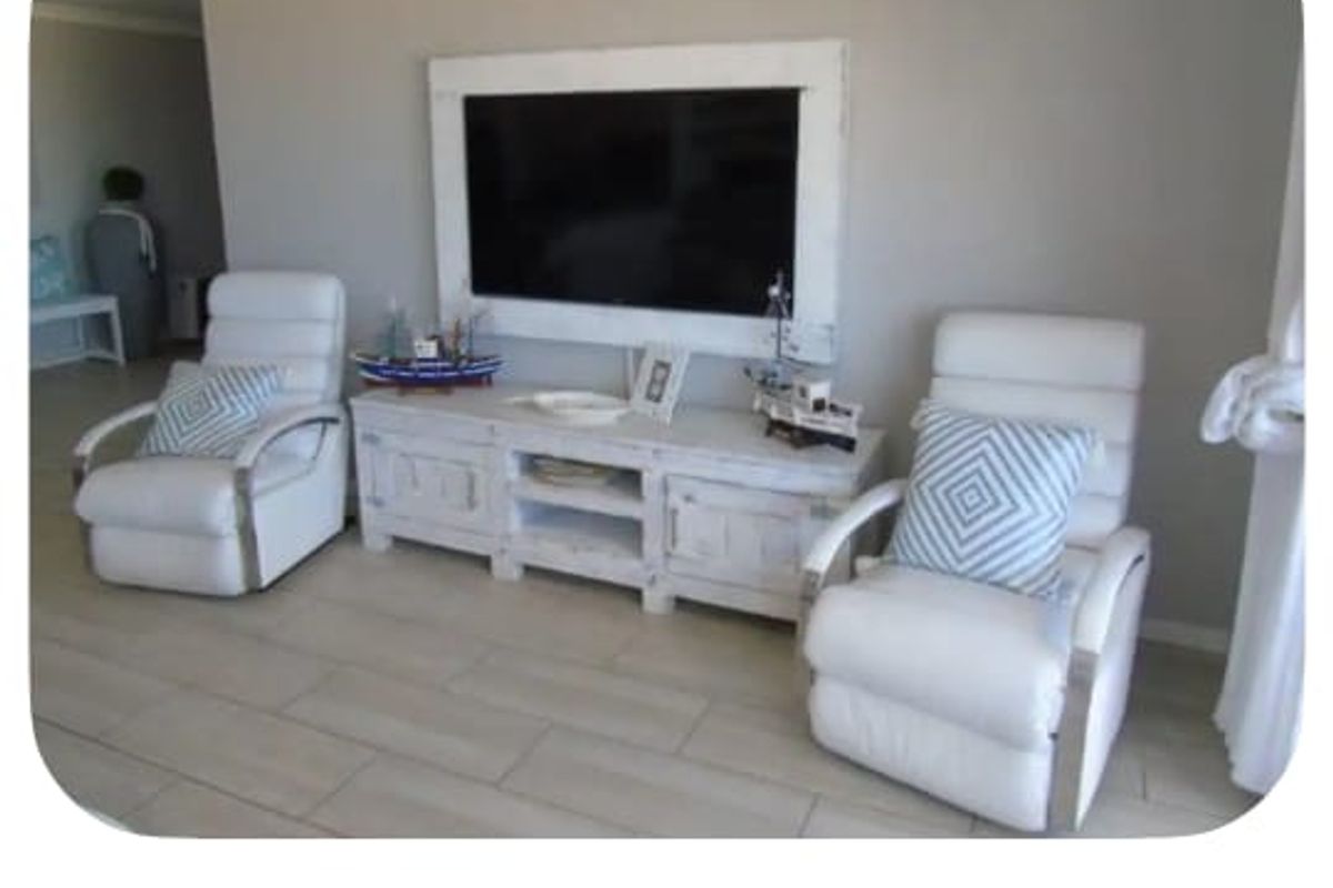 A bright living room featuring neutral tiled flooring and decorative coving, providing a clean and comfortable space for relaxation.