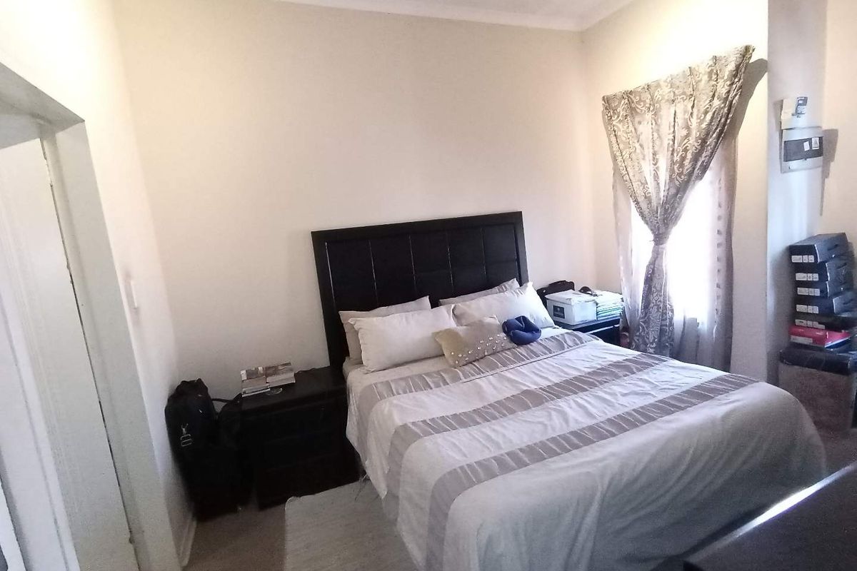A standard bedroom featuring neutral walls, coving, and an integrated electrical distribution board.