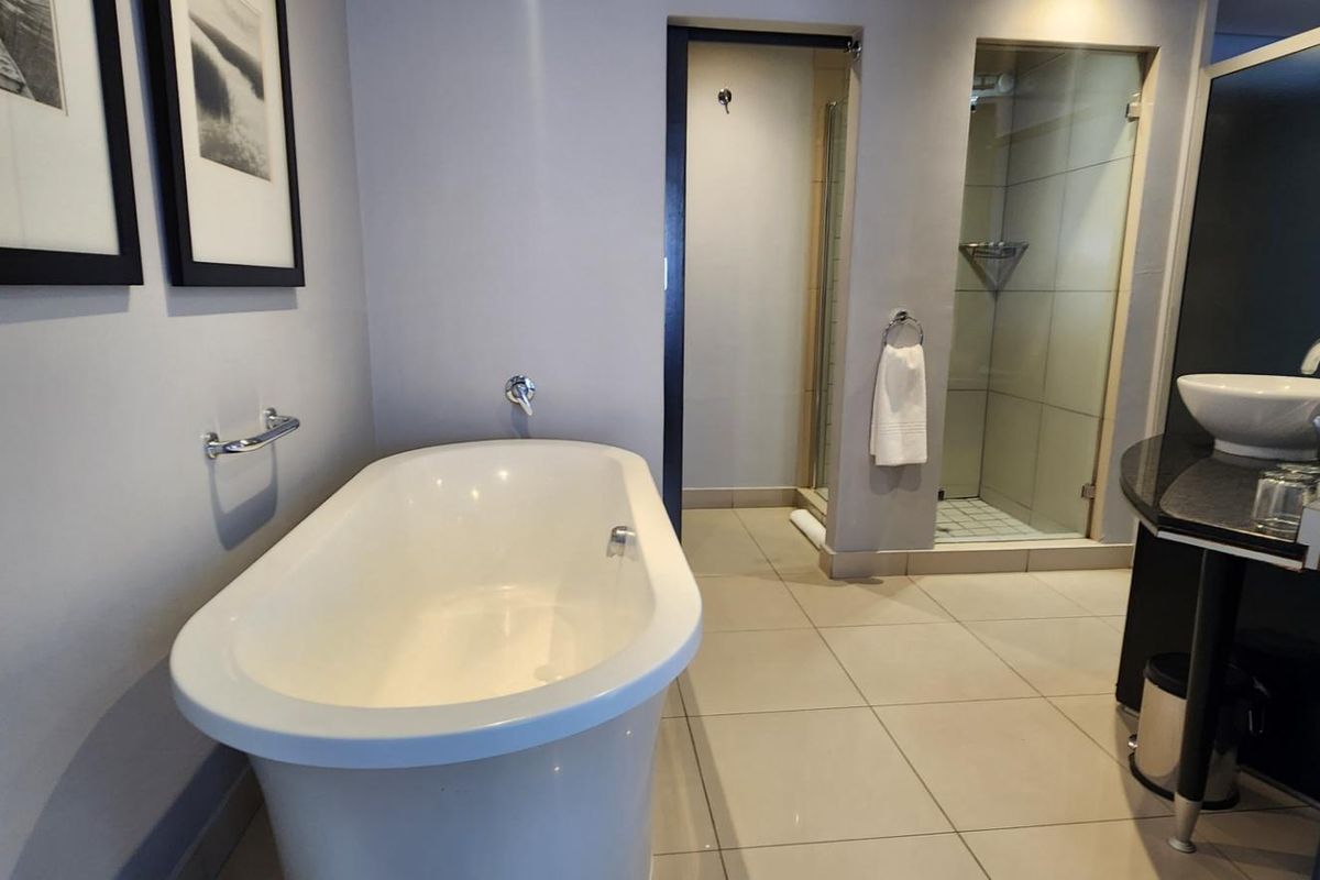 Modern bathroom featuring a sleek freestanding bathtub, a separate walk-in shower with glass enclosure, and a contemporary vessel sink vanity.