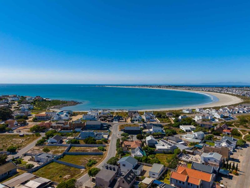 An elevated aerial view showcasing the coastal residential neighborhood and the expansive bay.