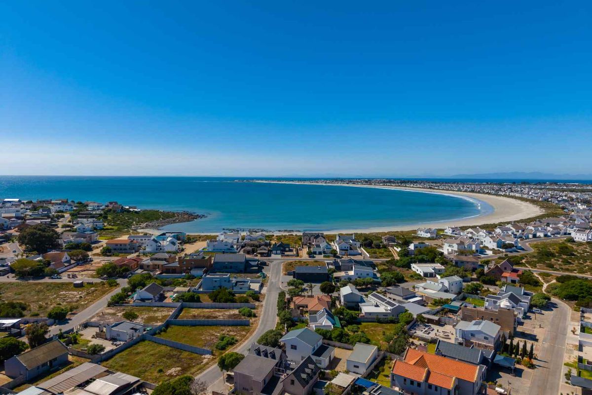 An elevated aerial view showcasing the coastal residential neighborhood and the expansive bay.