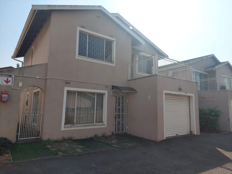 Front elevation of a two-story townhouse featuring a single garage, security gates, and an upper-level balcony.