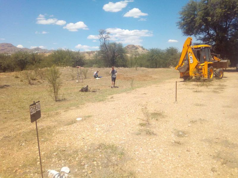 A view of a vacant commercial land plot featuring gravel access and natural terrain, suitable for future development.