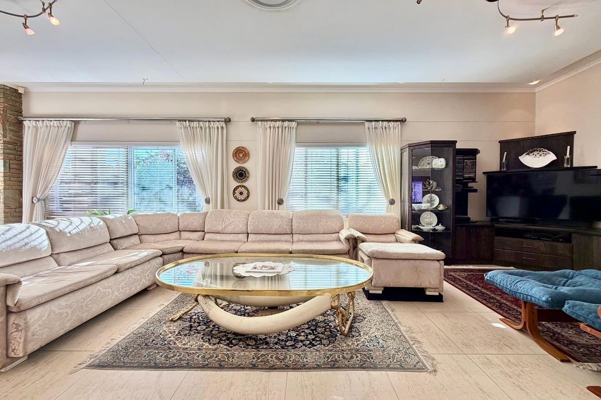 Spacious living room featuring large windows with blinds, tiled flooring, and recessed ceiling lighting.