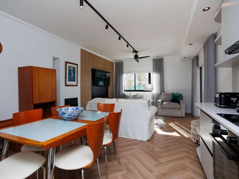 Modern open-plan living and dining area featuring herringbone timber flooring, a stylish timber slat feature wall, and a sleek, well-appointed kitchen.