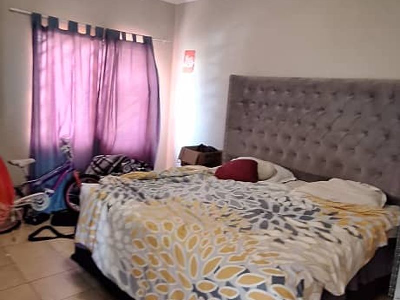 A bedroom featuring tiled flooring and a ceiling light fixture, providing a functional space for rest.