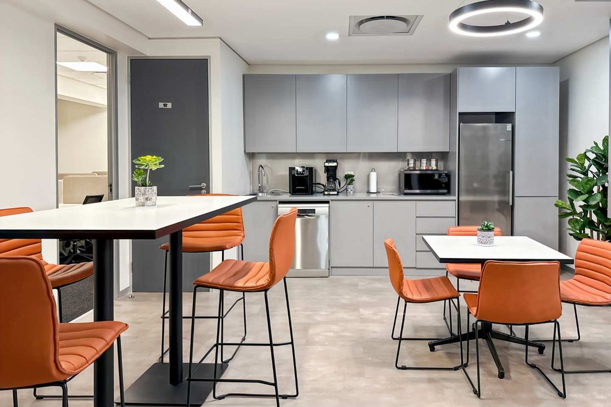 Modern office kitchenette featuring sleek grey cabinetry, integrated appliances, and a functional layout suitable for staff break areas.