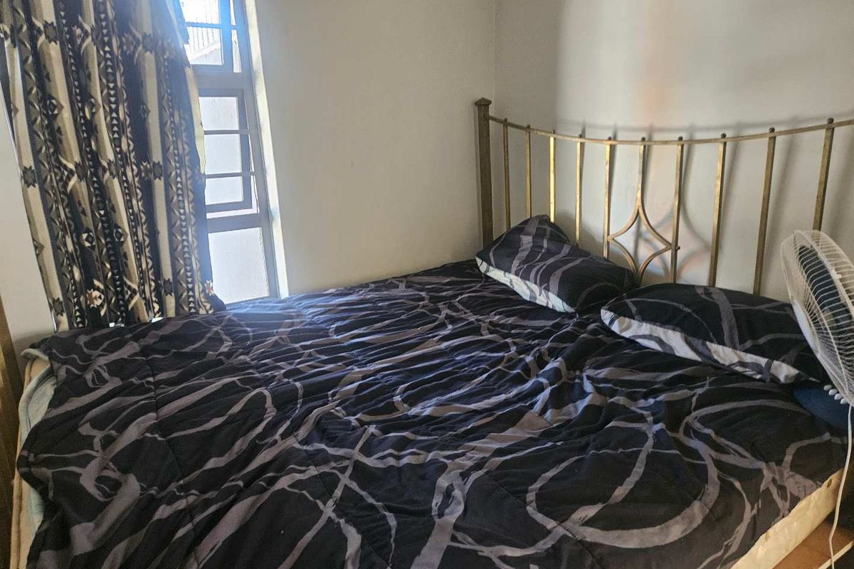 A bedroom featuring a window with natural light and neutral wall finishes.