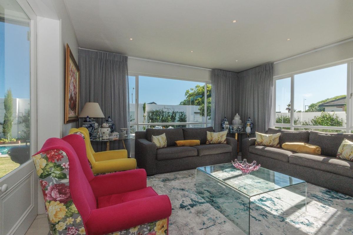 Bright and spacious living room featuring large windows that provide ample natural light and views of the garden area.