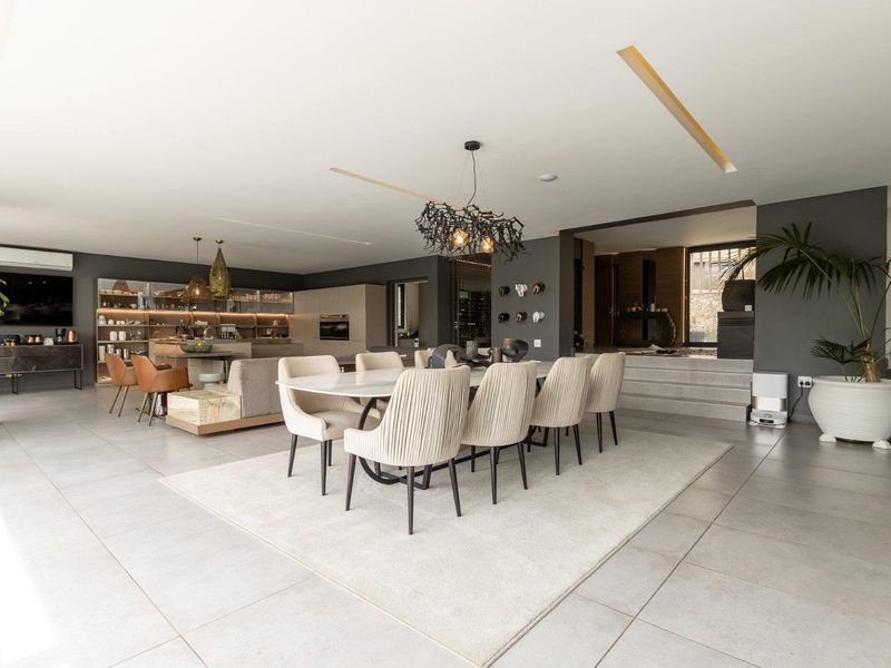 Spacious open-plan living and dining area featuring modern tiled floors, recessed ceiling lighting, and a sleek, well-appointed kitchen with integrated appliances.