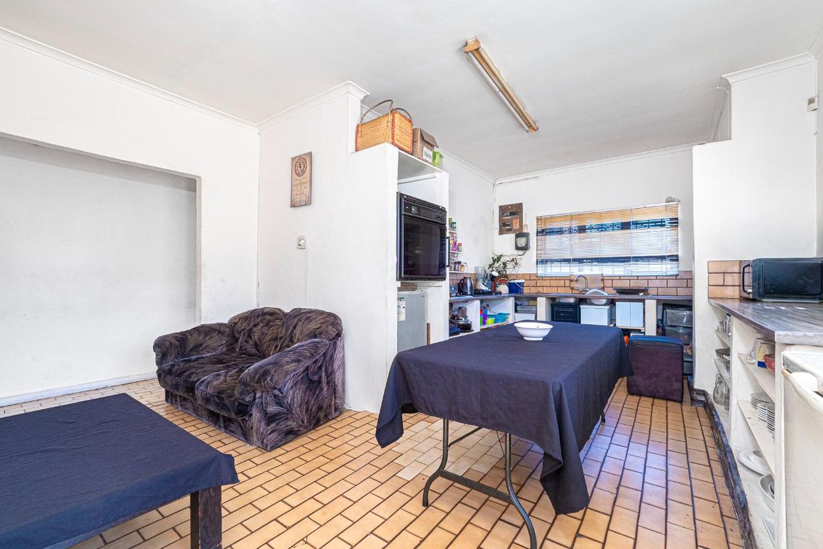 A dated kitchen area featuring tiled flooring, built-in oven, and basic cabinetry, offering significant potential for modernization and renovation.