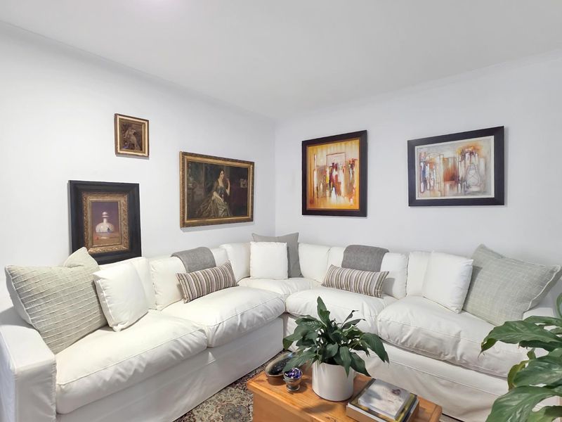 A well-maintained living room featuring neutral walls and a clean, bright aesthetic.