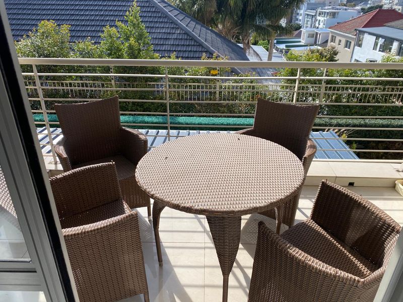 A well-maintained balcony featuring tiled flooring and a modern metal balustrade, offering an elevated outdoor space with neighbourhood views.