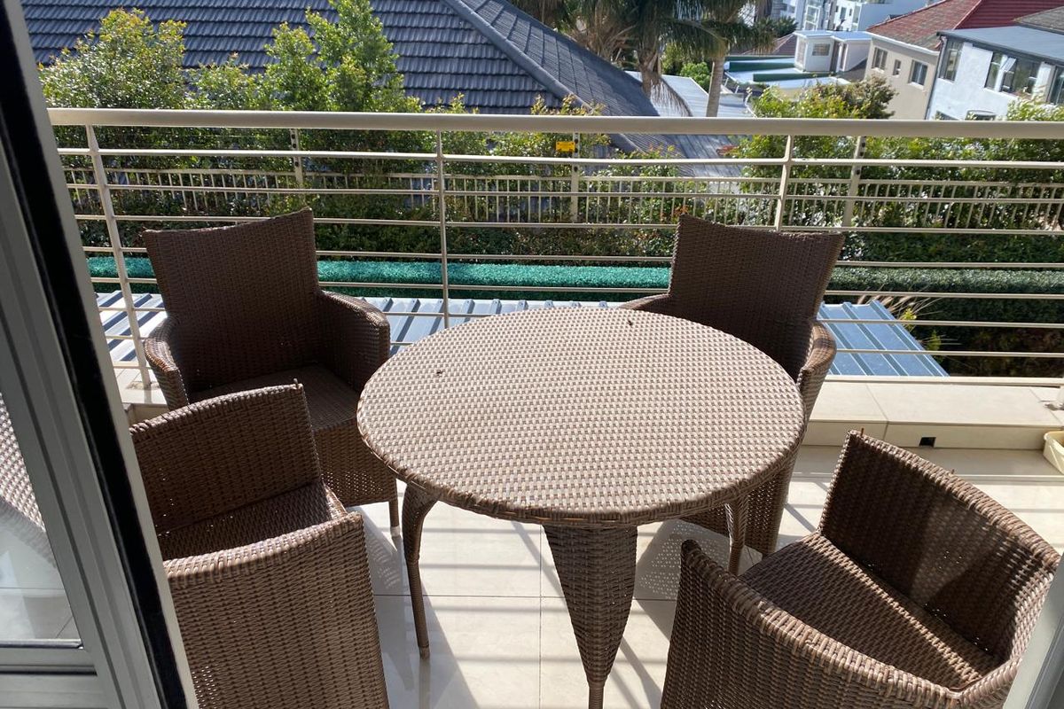 A well-maintained balcony featuring tiled flooring and a modern metal balustrade, offering an elevated outdoor space with neighbourhood views.