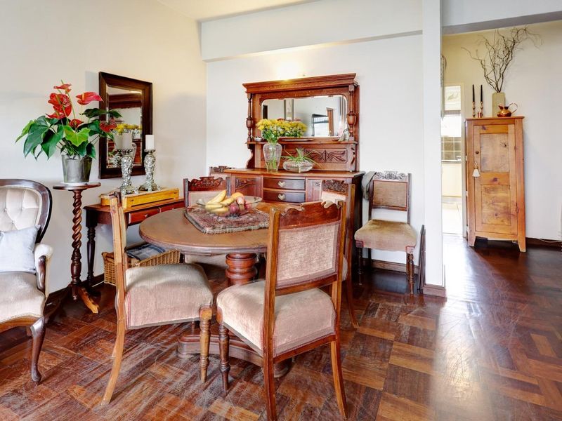 A dining room featuring classic parquet flooring and built-in cabinetry, offering a traditional aesthetic with potential for modern updates.