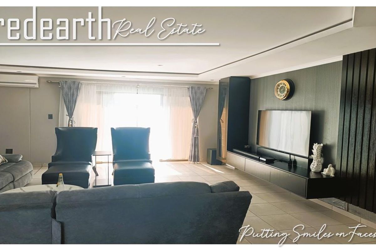 Spacious living room featuring tiled flooring, recessed ceiling lighting, a wall-mounted air conditioning unit, and custom built-in media cabinetry.
