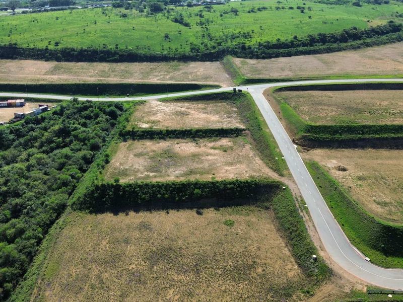 Aerial view of a vacant industrial land plot featuring terraced terrain, established retaining embankments, and direct access to a paved road network.