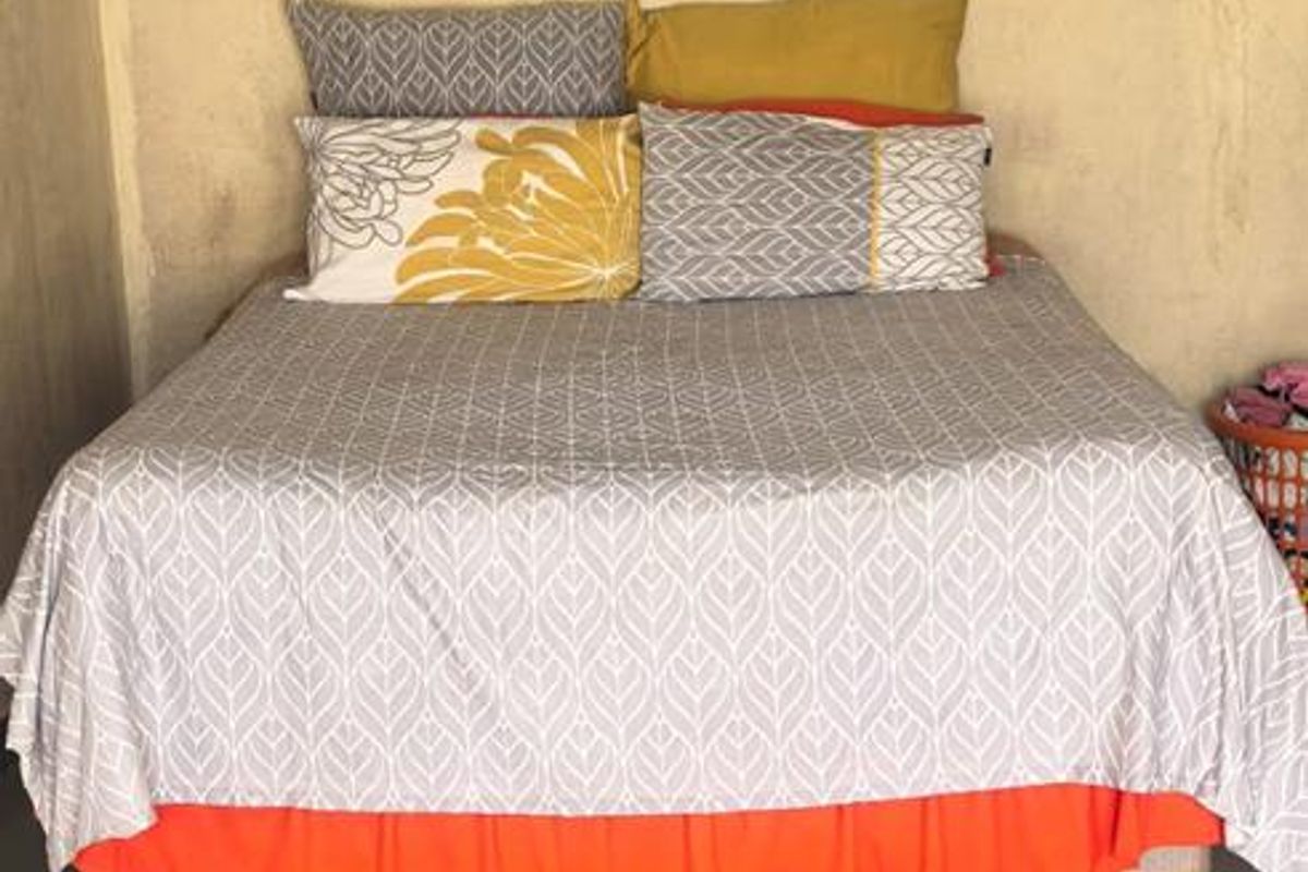 A bedroom featuring tiled flooring and visible wall damage, requiring cosmetic attention and repairs to the wall and ceiling finishes.