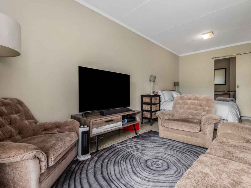 Open plan living area featuring tiled flooring and a sliding door leading to an adjacent bedroom space.