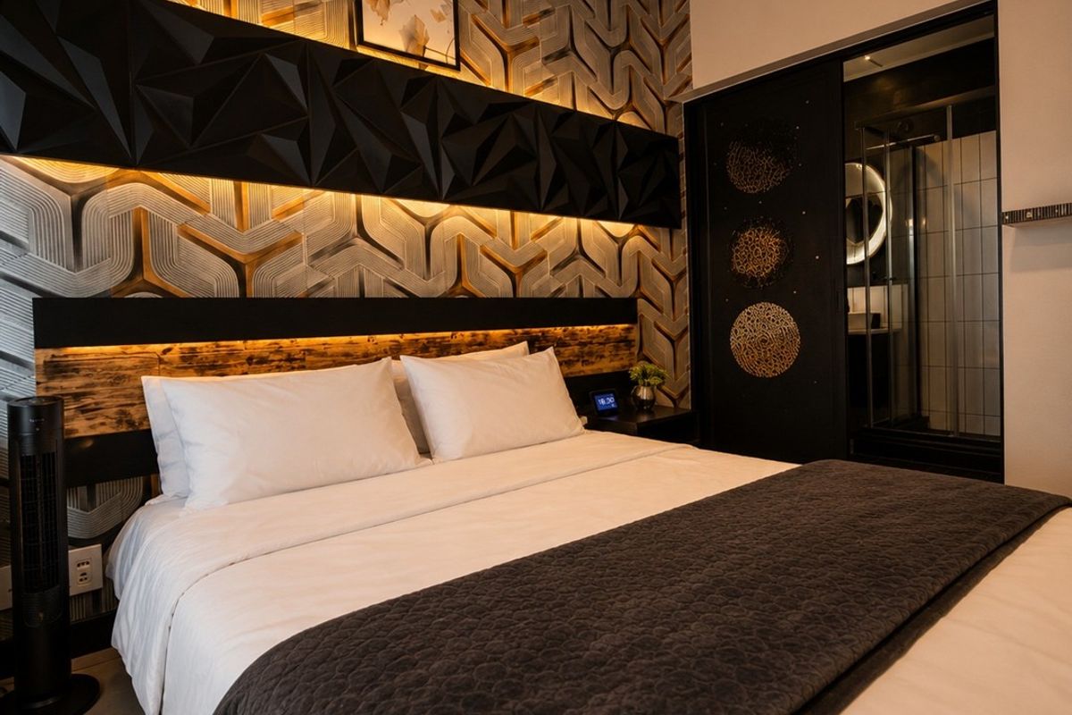 Modern bedroom featuring a striking textured feature wall with integrated LED lighting and convenient access to an en-suite bathroom.