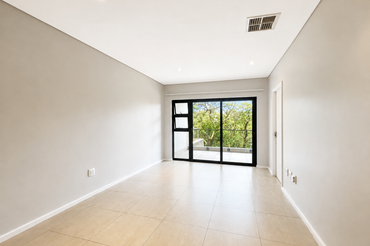 A bright, empty bedroom featuring neutral tiled flooring, recessed lighting, and a large sliding glass door providing access to an outdoor balcony.