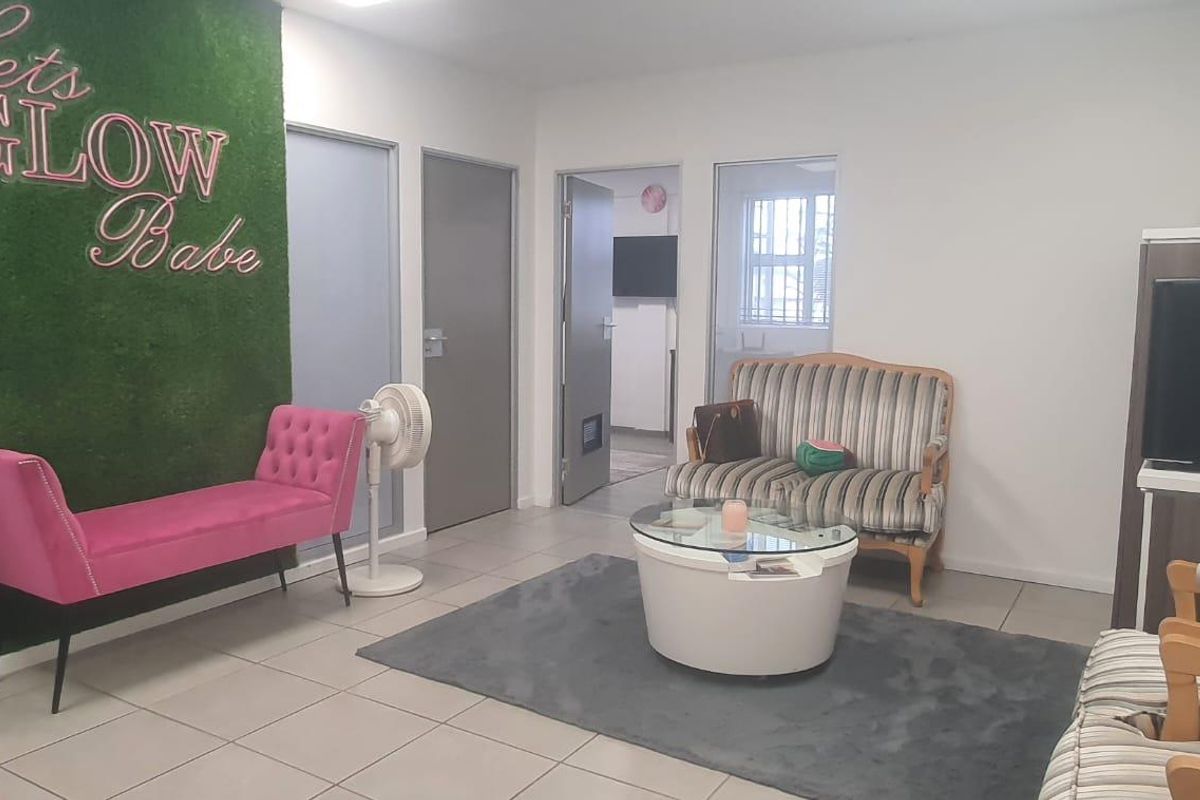 A functional reception or waiting area featuring tiled flooring, neutral walls, and access to multiple internal rooms.