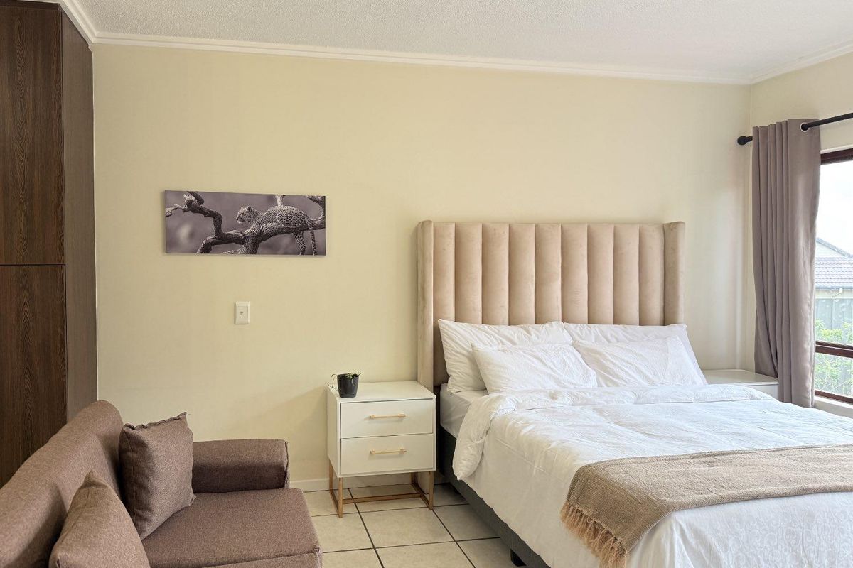 A well-maintained bedroom featuring tiled flooring, built-in cabinetry, and a large window allowing for natural light.