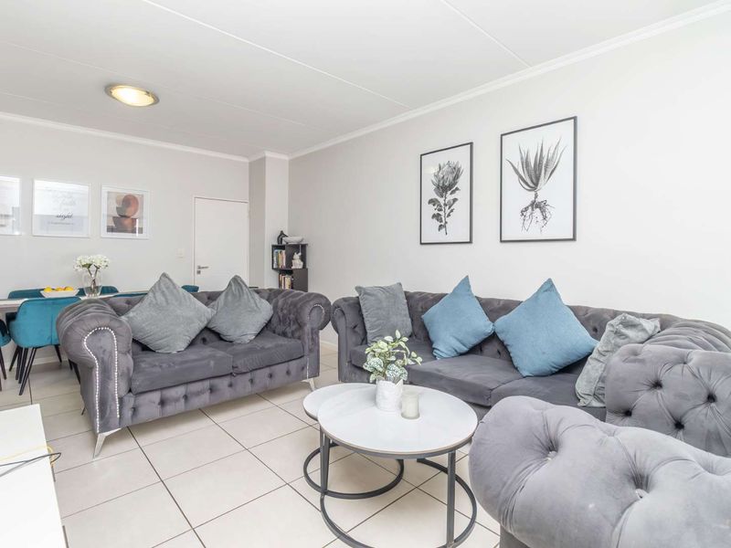 Spacious open-plan living and dining area featuring neutral tiled flooring and clean, well-maintained finishes throughout.