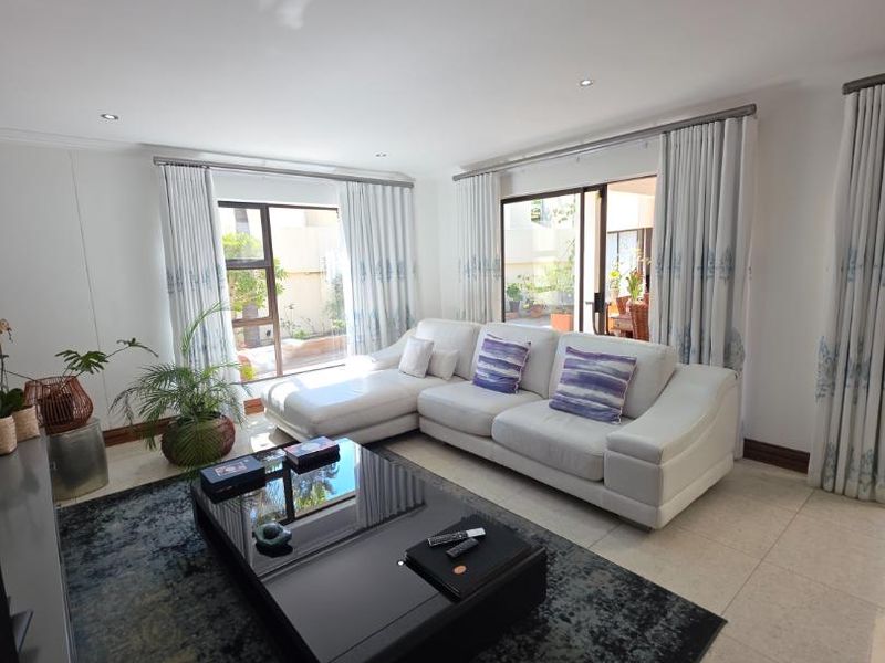 A bright and spacious living room featuring large sliding glass doors that provide natural light and direct access to the outdoor patio area.