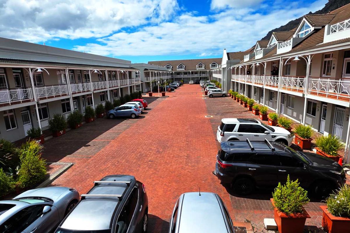 A well-maintained office complex courtyard featuring paved ground, multiple levels with balconies, and structured exterior architecture.