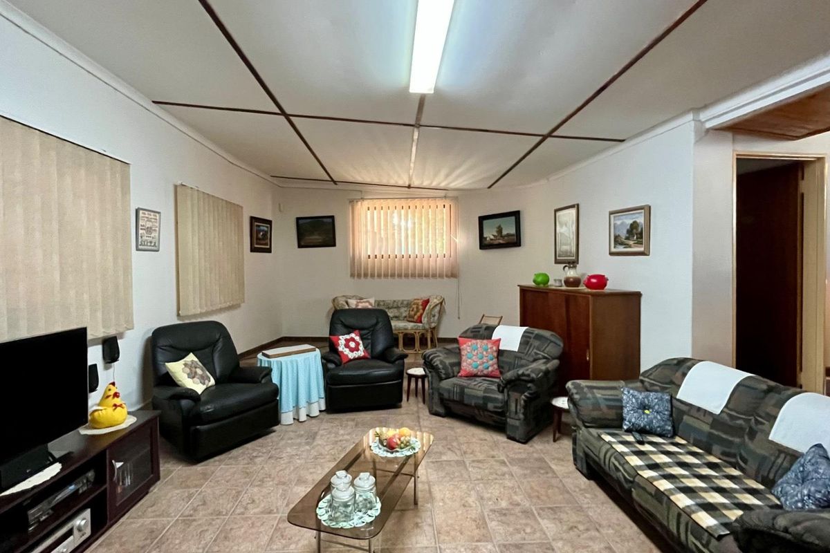 A spacious living room featuring tiled flooring and a traditional ceiling design, offering a comfortable and functional area for relaxation.