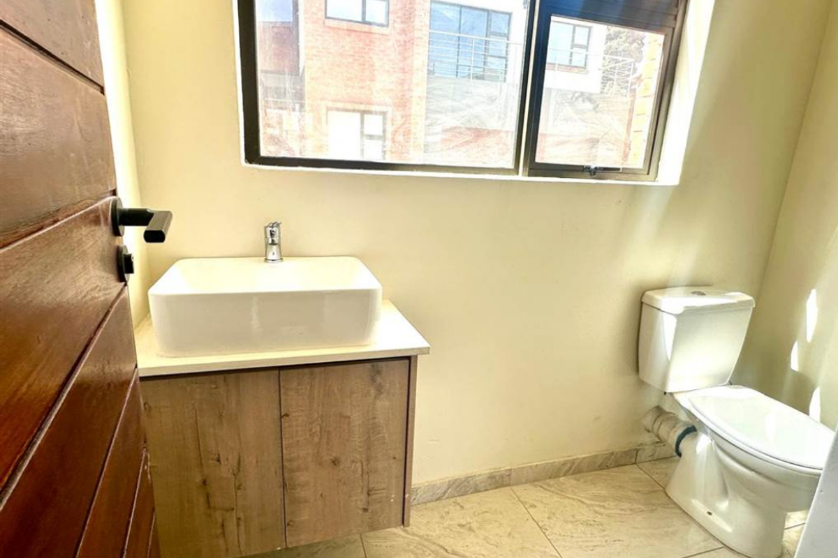 A compact guest bathroom featuring a modern vessel sink vanity, tiled flooring, and a standard toilet.