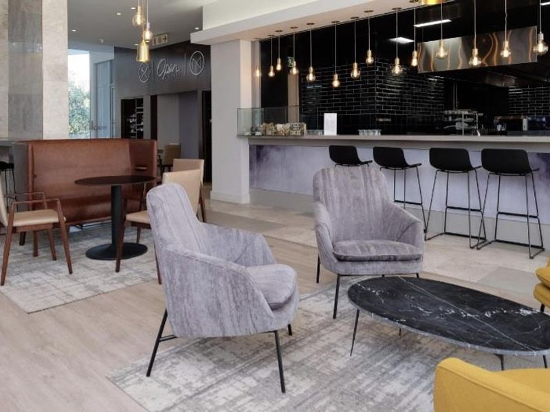 Modern open-plan living and dining area featuring a sleek built-in bar counter, contemporary pendant lighting, and high-quality finishes throughout.