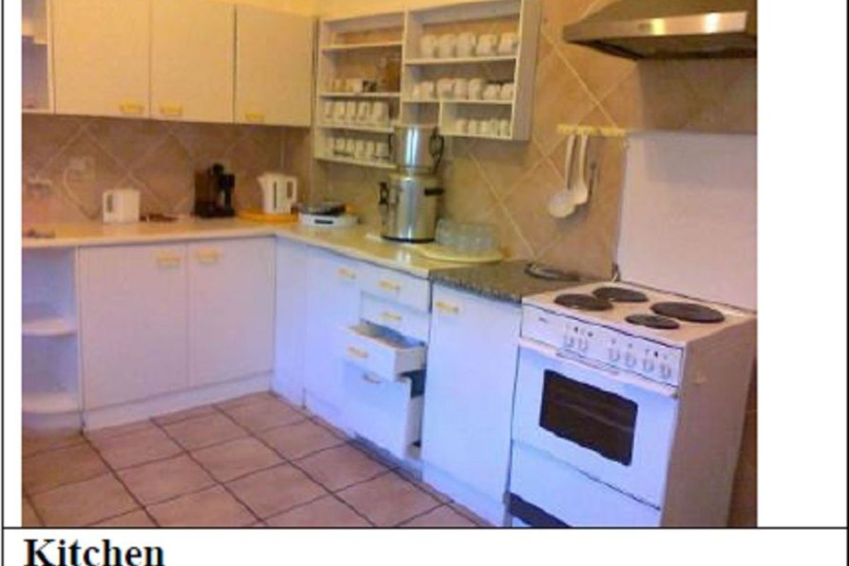 A functional kitchen featuring white cabinetry, tiled flooring, a tiled backsplash, and a freestanding electric stove with an overhead extractor fan.