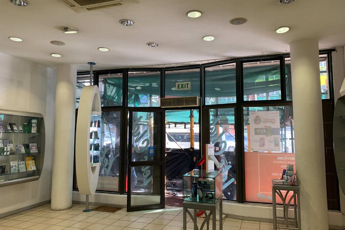 Retail entrance area featuring tiled flooring, large glass storefront windows, recessed lighting, and built-in display shelving, suitable for a variety of commercial uses.