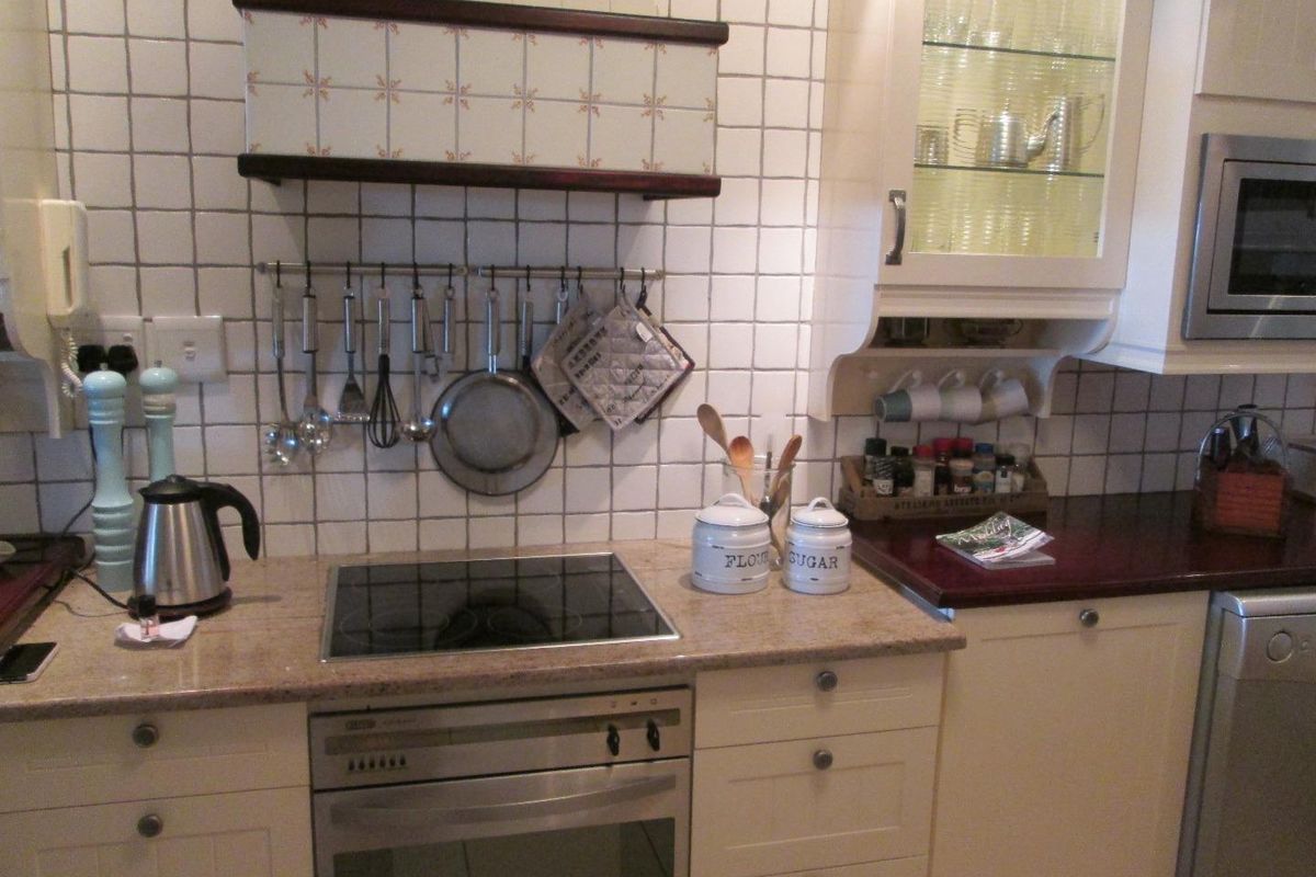 A functional kitchen featuring a built-in oven, electric cooktop, integrated microwave, and tiled backsplash with ample cabinetry storage.