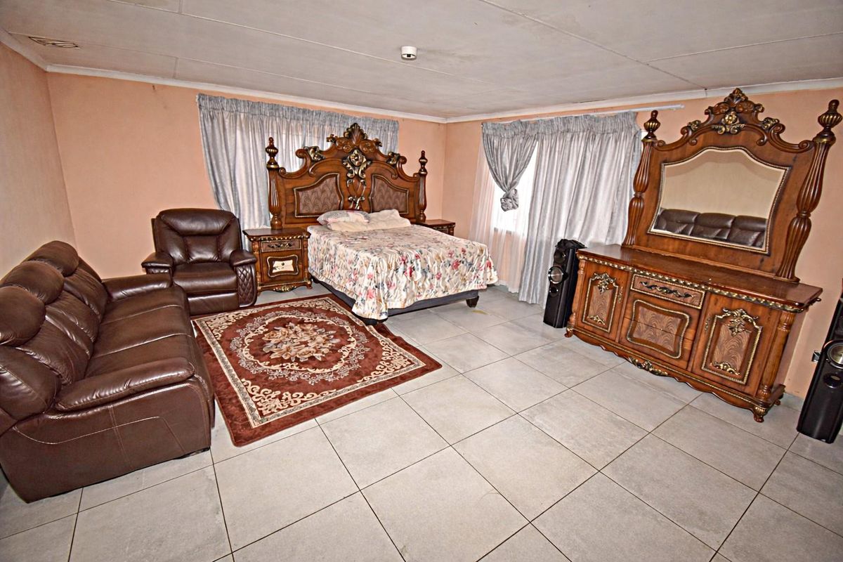 Spacious bedroom featuring large format floor tiles and neutral wall finishes, offering a blank canvas for modernization.