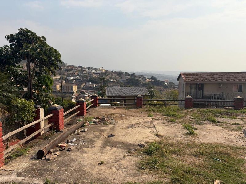 An elevated outdoor area featuring brick pillars and timber fencing, offering an expansive view over the surrounding residential neighbourhood.