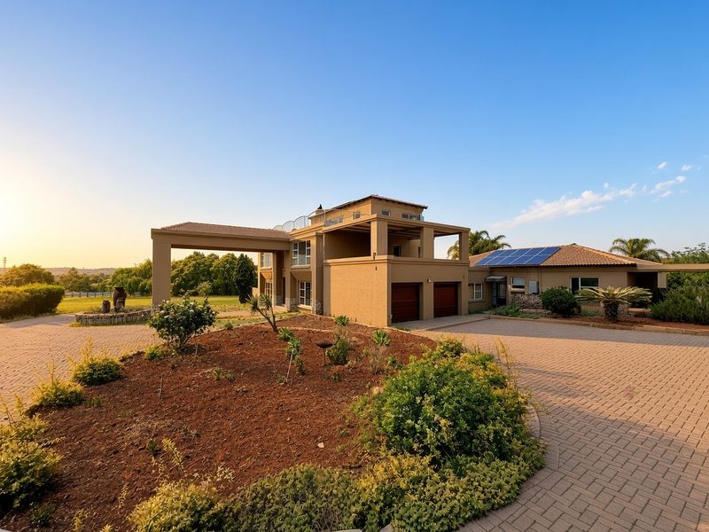 A spacious multi-level residence featuring a paved circular driveway, double garage, covered porte-cochere, and roof-mounted solar panels set in a landscaped environment.
