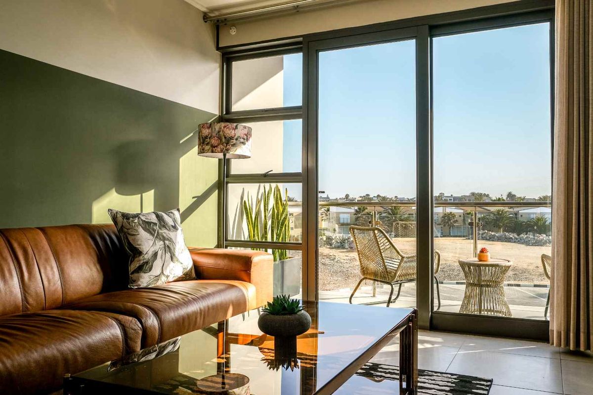 A bright living room featuring large sliding glass doors that provide natural light and access to an outdoor balcony area.