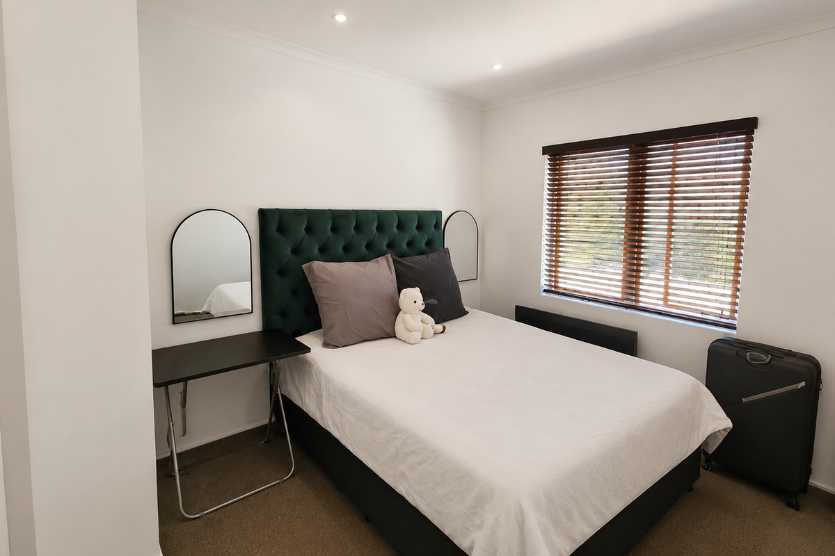 A well-maintained bedroom featuring neutral walls, carpeted flooring, recessed downlighting, and venetian blinds for natural light control.
