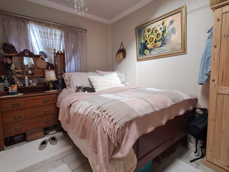 A compact bedroom featuring tiled flooring and decorative ceiling cornicing, providing a functional space for rest.