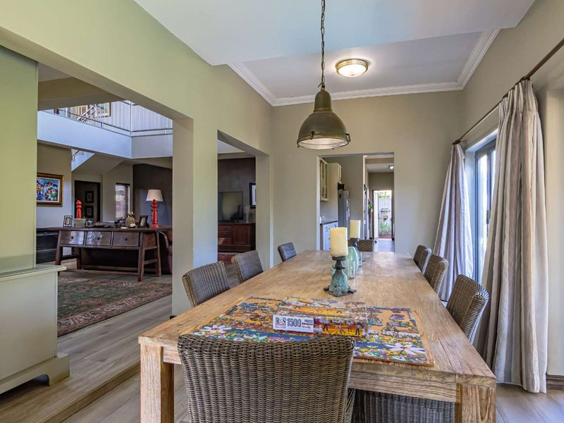 Spacious dining area featuring laminate flooring, crown molding, and sliding glass doors that provide natural light and access to the exterior.