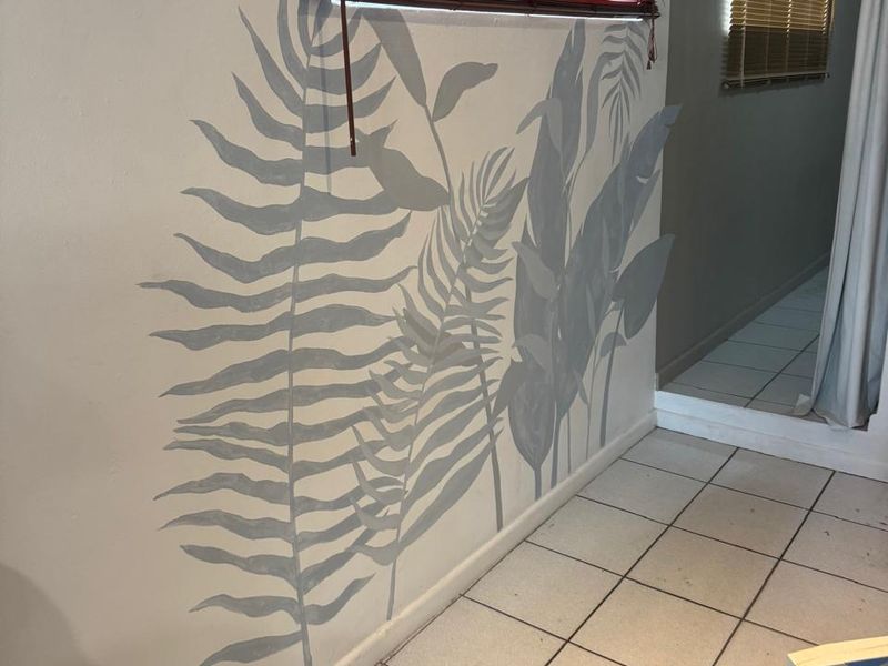 A bedroom space featuring tiled flooring, venetian blinds, and a full-length mirror, currently vacant and ready for restyling.