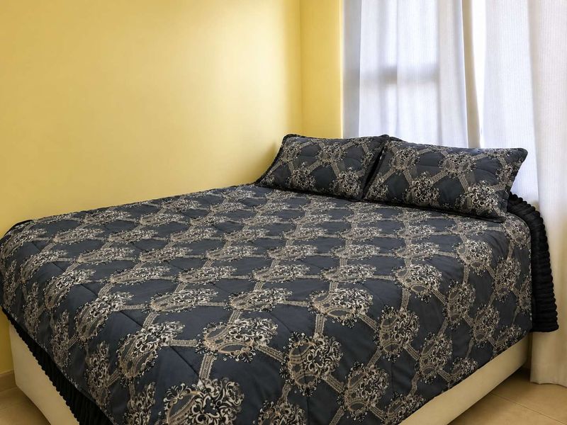 A bedroom featuring tiled flooring and yellow painted walls, providing a functional space for rest.