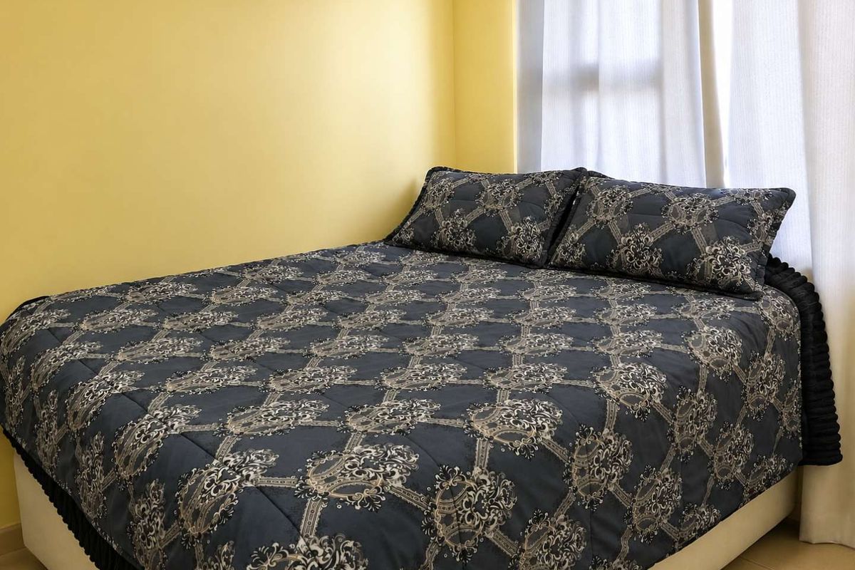 A bedroom featuring tiled flooring and yellow painted walls, providing a functional space for rest.